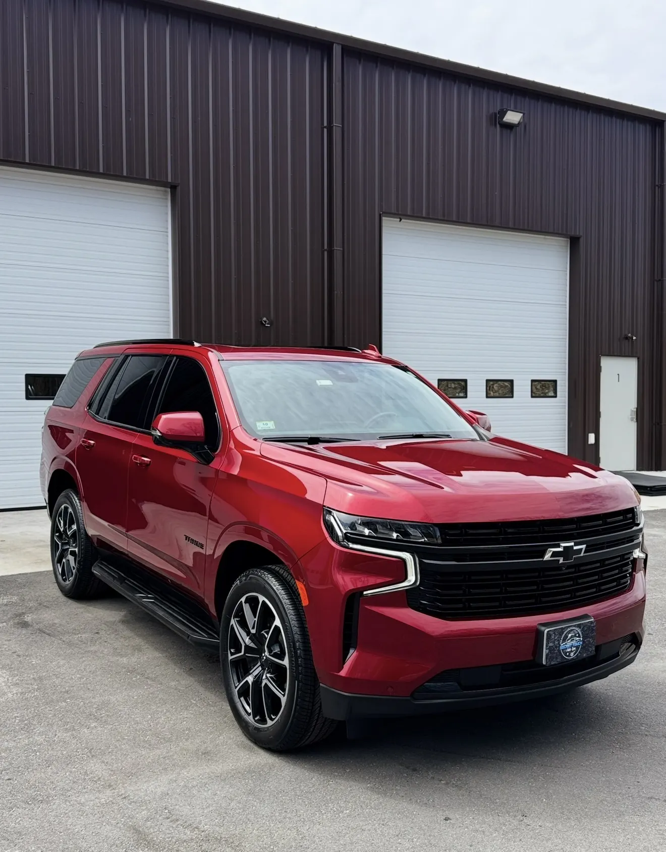 Red Chevrolet Tahoe RST after paint correction and ceramic coating outside in natural light at Secret Touch Auto Spa Shrewsbury MA