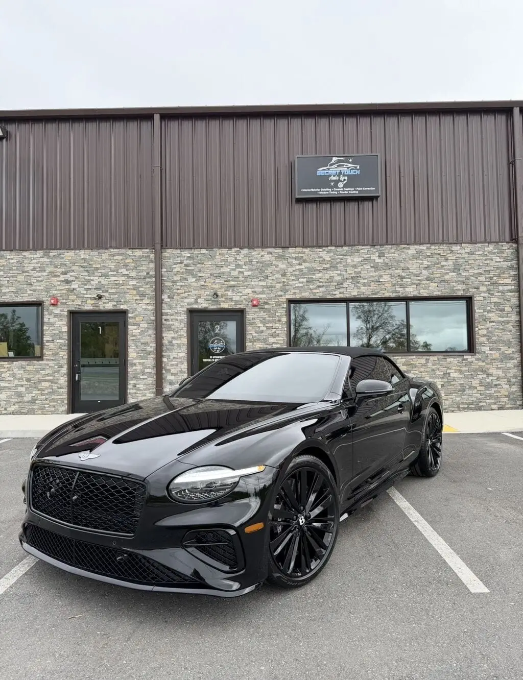 Bentley Continental GT in gloss black with freshly ceramic coated wheels and brake calipers, parked at Secret Touch Auto Spa studio in Shrewsbury, Massachusetts